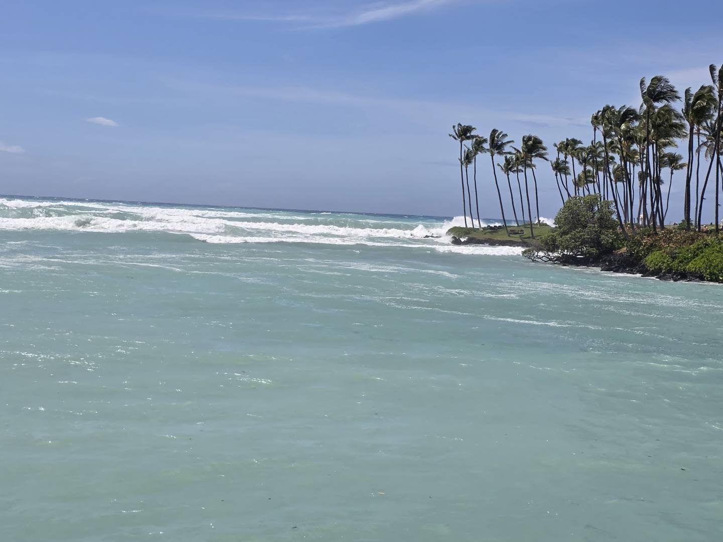 Milky green turbid water against the rocky point at Waikoloa during the swell